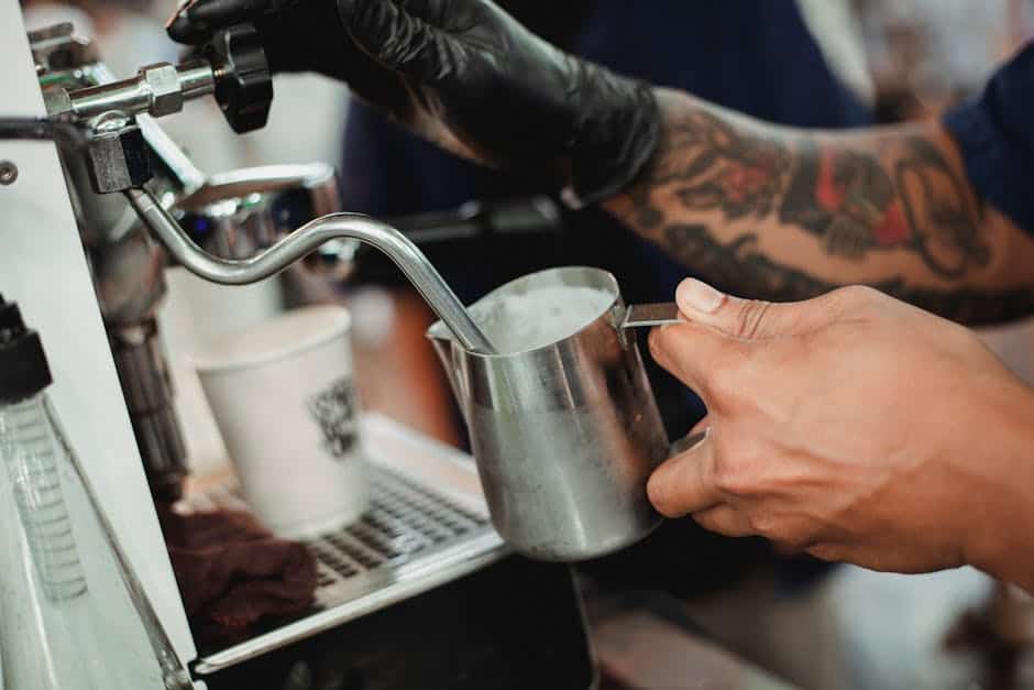 A skilled barista carefully steams milk to create the perfect foam consistency for a cappuccino